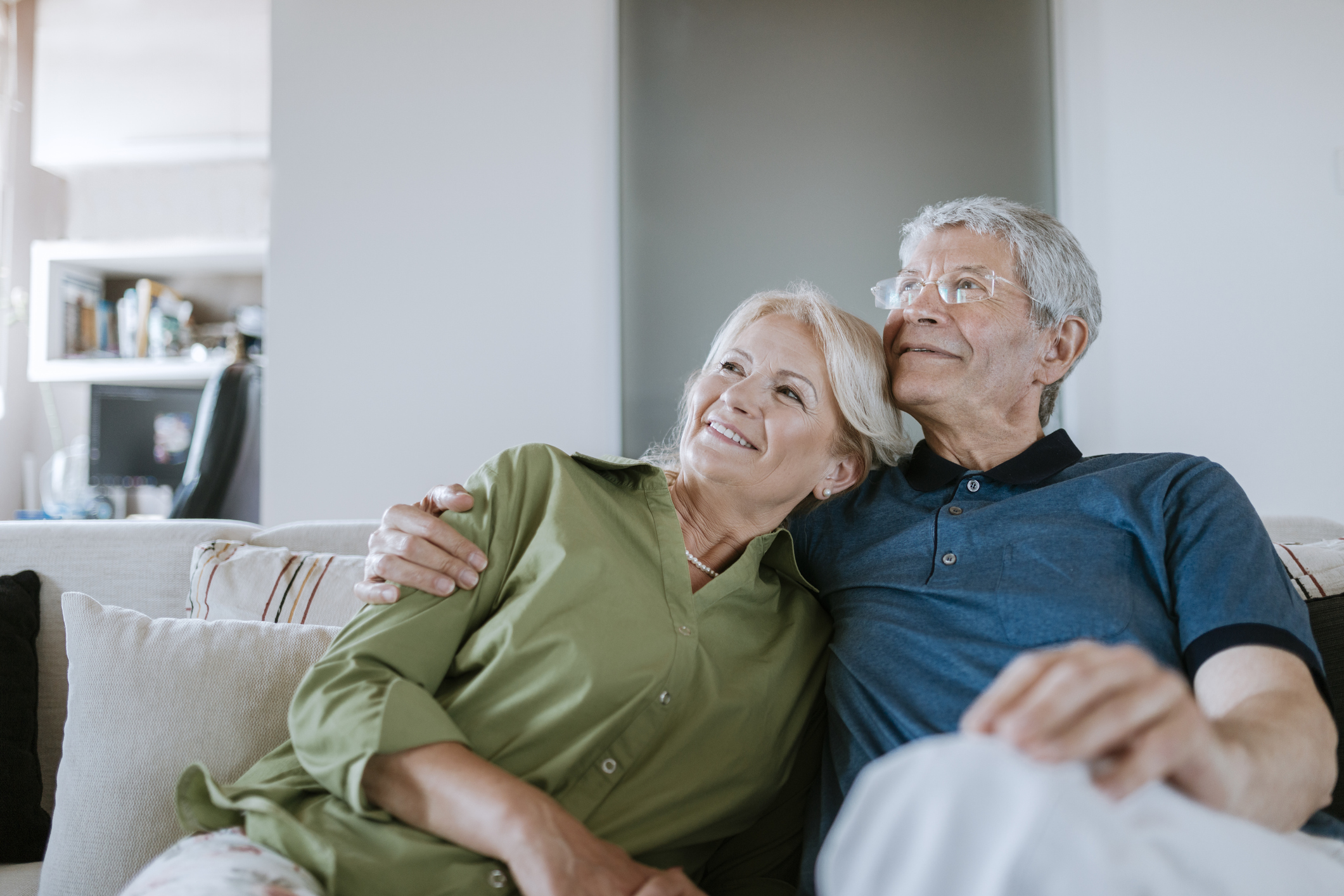Smiling senior couple sitting on couch at home